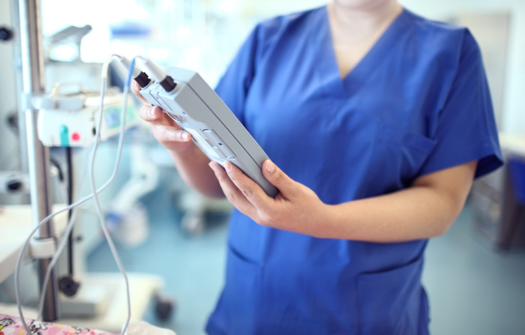 Nurse holds a patient monitoring machine